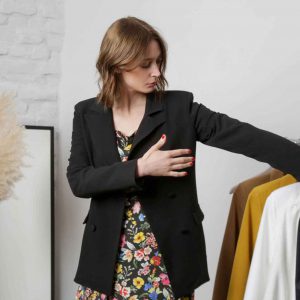 femme choisissant des vêtements accrochés sur un présentoir