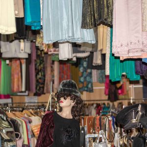 vue de l'intérieur d'une boutique avec une multitude de vêtements accrochés au plafond et suspendus sur des cintres
