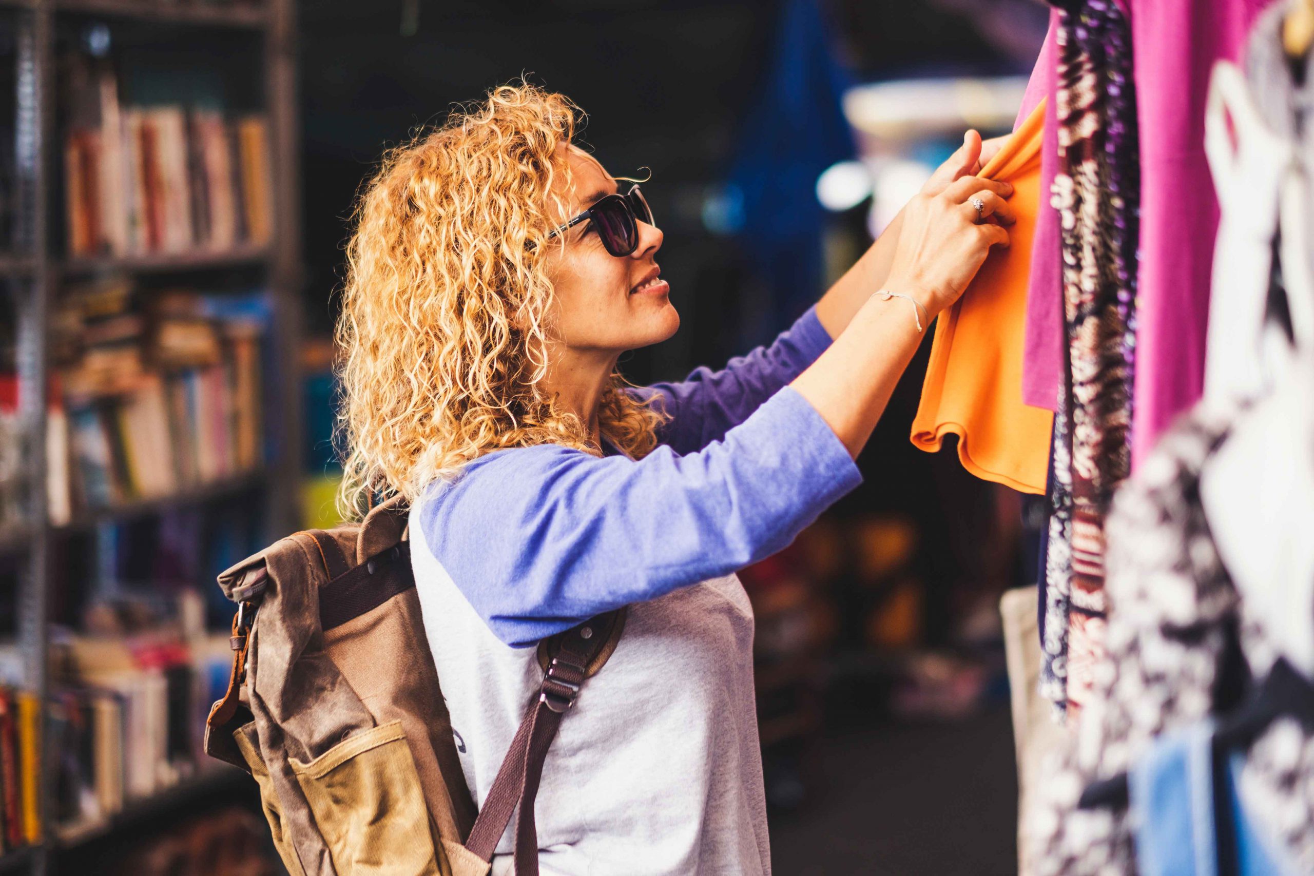 une femme regarde des vêtements accrochés à un présentoir