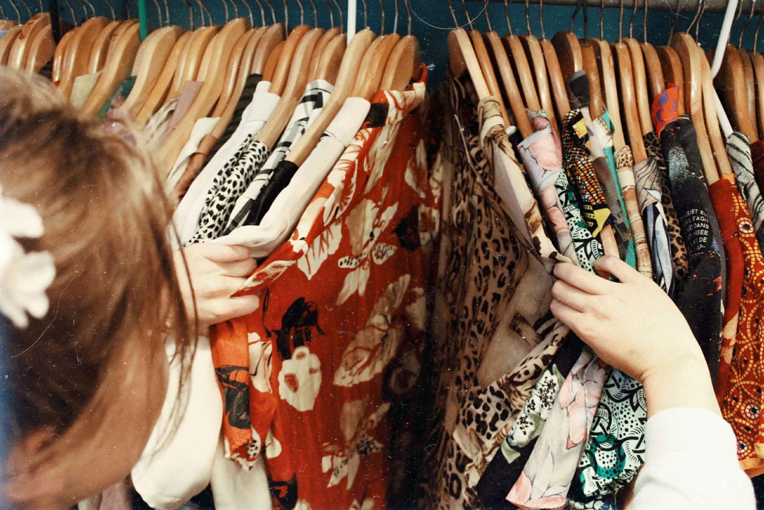 femme choisissant des vêtements accrochés sur un présentoir